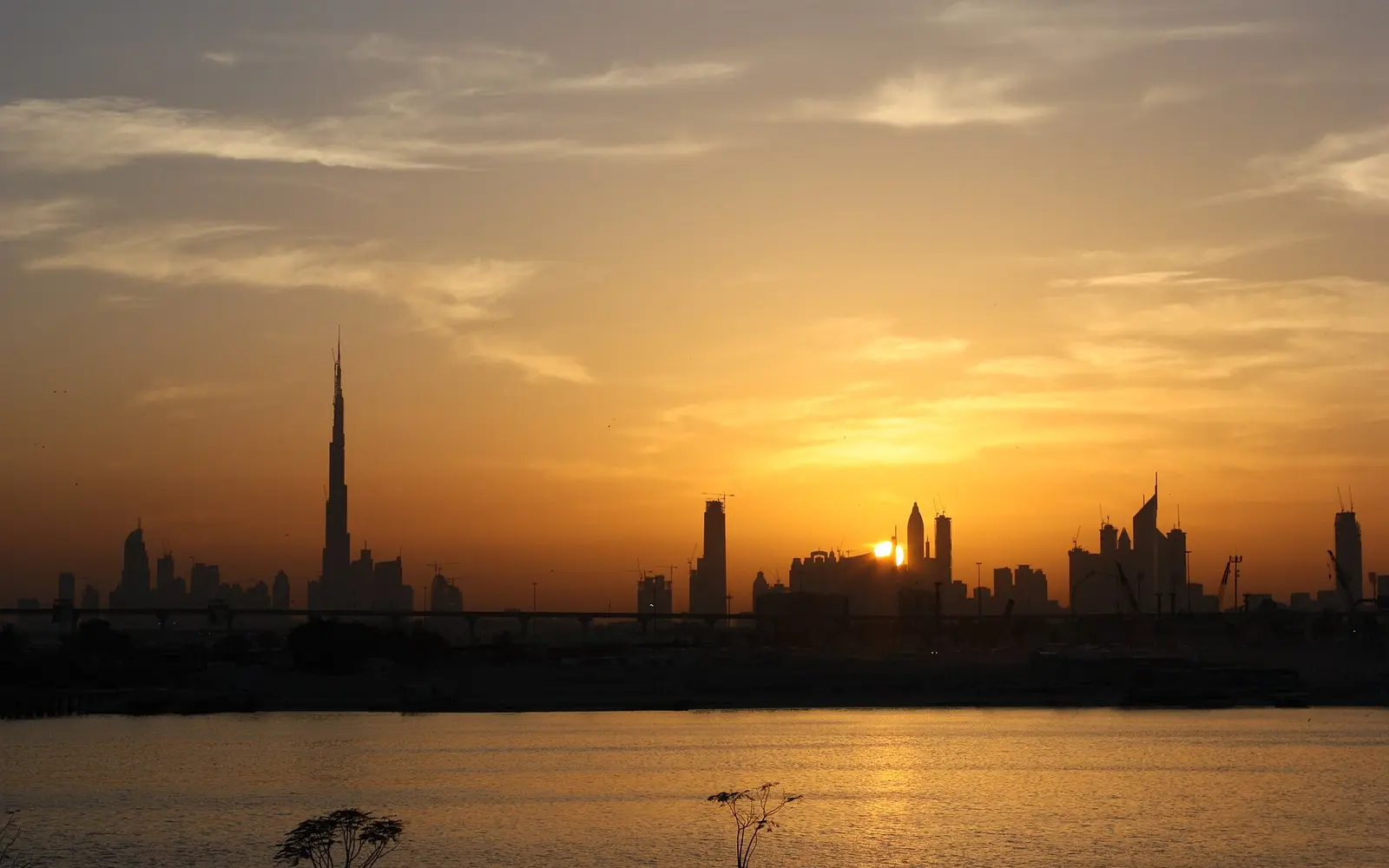 Dubai skyline at sunset with Burj Khalifa in the distance