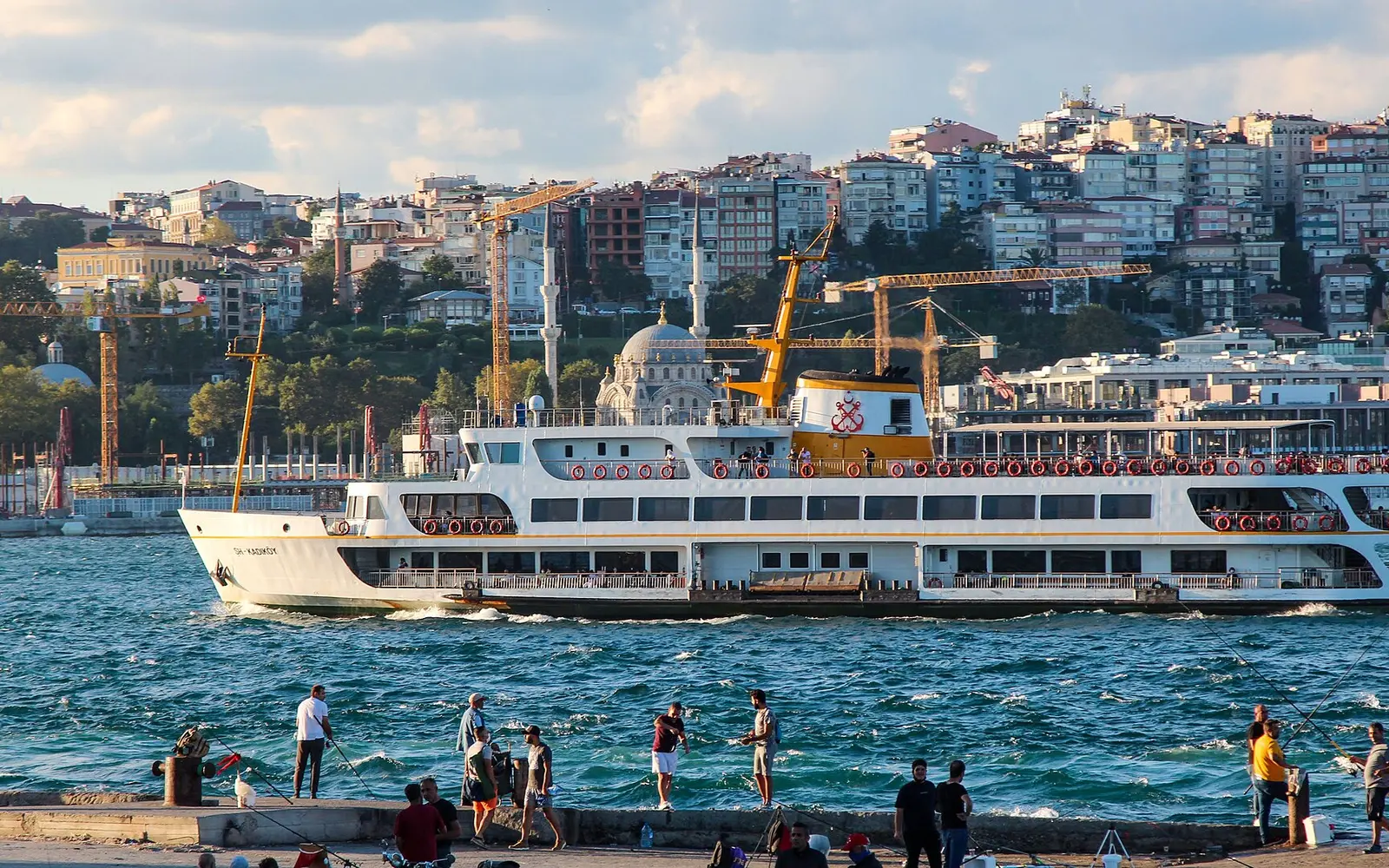 A city ferry crossing the Bosphorus in front of the Istanbul waterfront
