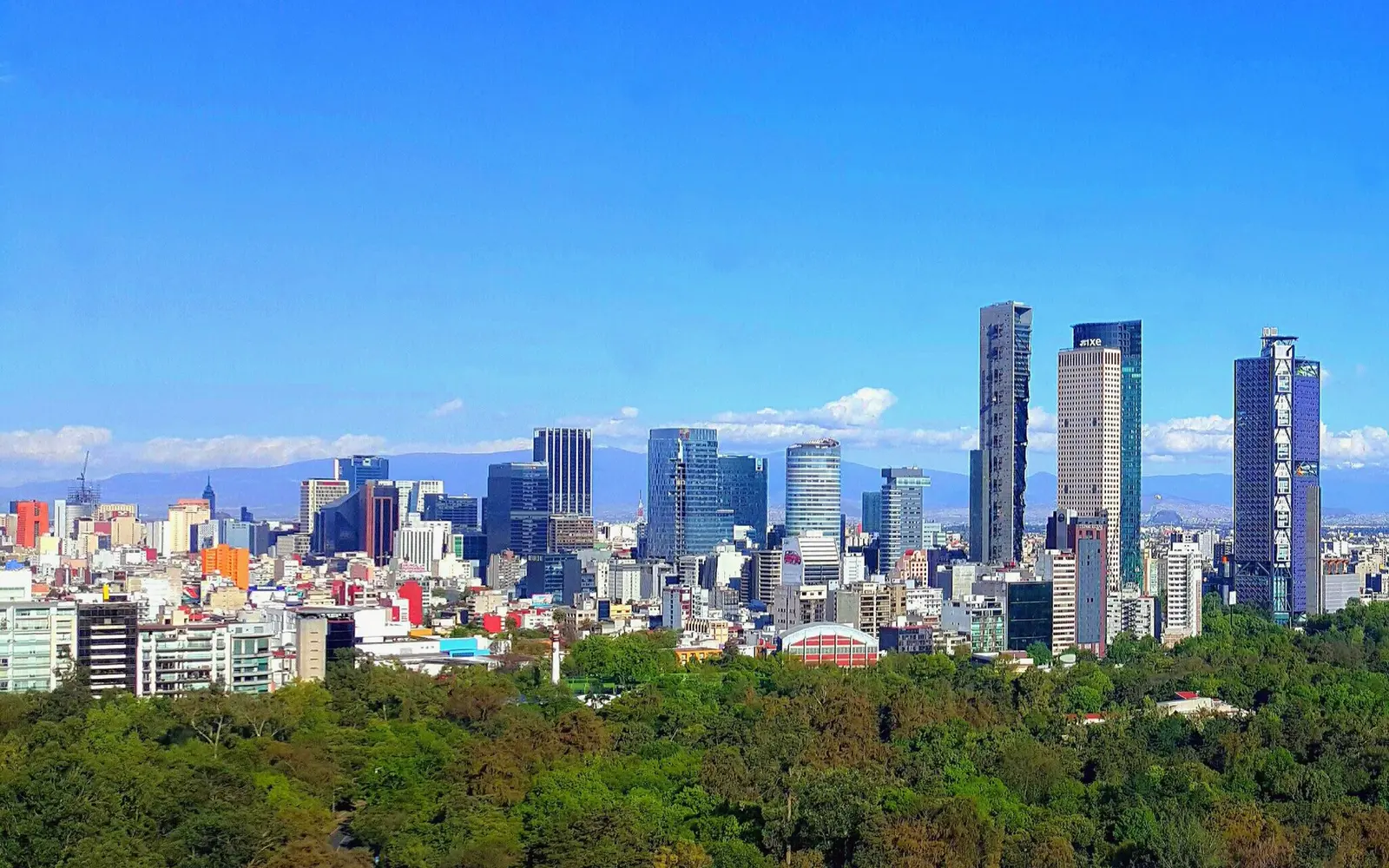 Mexico City skyline along Paseo de la Reforma with mountains in the distance